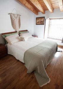 ein Schlafzimmer mit einem großen Bett und einem großen Fenster in der Unterkunft B&B In Contrá in Selva di Progno