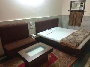 a small room with a bed and a table at Hotel Prince in Guwahati