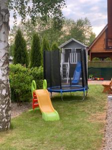a playground with a play set and a house at Pod brzozą in Chłopy