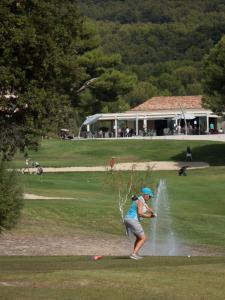 Eine Frau spielt Golf in einem Park in der Unterkunft Les Pins, Provence Country Club in Saumane-de-Vaucluse