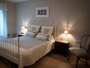 a bedroom with a bed with two pillows and a chair at Les Pins, Provence Country Club in Saumane-de-Vaucluse