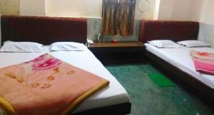 Hotel Prince في غاواهاتي: سريرين في غرفة الفندق وعليهم منشفة