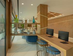 a lobby with a bar with two monitors and chairs at AJ Gran Alacant by SH Hoteles in Santa Pola +31 photos
