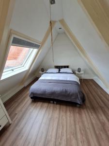 a bedroom with a bed in a attic at Slapen in Herbaijum in Herbaijum