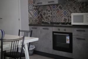 una cucina con forno a microonde, piano cottura e tavolo di Sweet Sleep a Catania