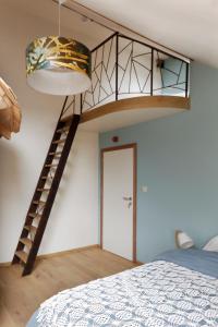 - une chambre avec une mezzanine et un escalier dans l'établissement Cochlea, à Marche-en-Famenne