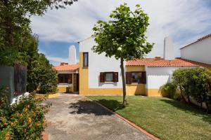 una casa con un árbol en el patio en ALTIDO 3-BR Cottage with Terrace and Garden in Colares en Sintra