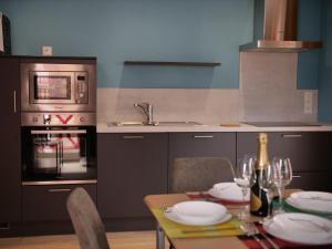 a kitchen with a table with plates and wine glasses at Plage à 50m Appartement Rêves bleus Villa Les Bains de Mers in Mers-les-Bains