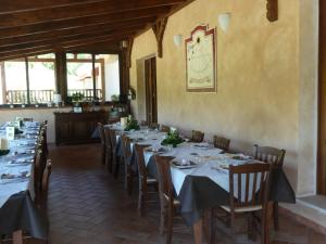 una sala da pranzo con tavoli, sedie e un orologio sul muro di Agrilao a Scalea
