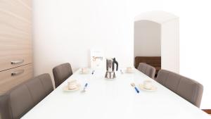 una sala conferenze con tavolo e sedie bianchi di Alloggio da Paolina a Castellaneta