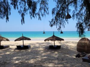 
a beach with umbrellas and chairs on it at Long Beach Chalet - SHA Extra Plus in Ko Lanta
