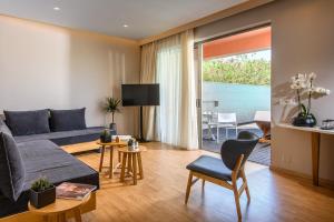 a living room with a couch and a table at Stella Palace Aqua Park Resort in Hersonissos