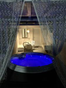 uma grande banheira azul num quarto com uma cortina em Mykonos Secret Spot em Míconos