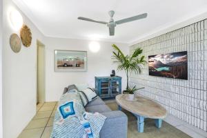ein Wohnzimmer mit Sofa und Tisch in der Unterkunft Tropicana Hideaway in Cairns North + 1 Foto