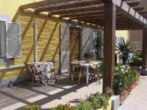 里奥马里纳Appartamenti Claudia Rio的凉亭下的露台配有2张桌子和椅子
