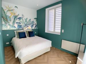 Un dormitorio con una cama con paredes azules y una ventana en Appartement l'émeraude à Saint Malo Intra-Muros, en Saint-Malo