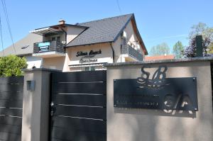 een huis met een zwarte poort voor een hek bij Silver Beach Apartments in Siófok