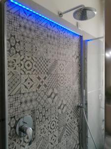 a shower with a glass door with a blue light at ANGELA GUEST HOUSE in centro storico in Conegliano +7 photos