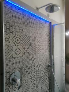 a shower with a glass door with a blue light at ANGELA GUEST HOUSE in centro storico in Conegliano