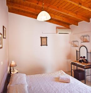 a bedroom with a bed and a desk in a room at Marilou's Cottage in Ágios Matthaíos