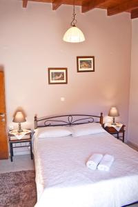 a bedroom with a large bed with two towels on it at Marilou's Cottage in Ágios Matthaíos