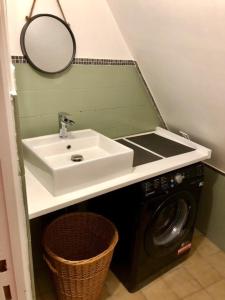 a bathroom with a sink and a washing machine at La Closerie - trois chambres in Vicq-sur-Gartempe