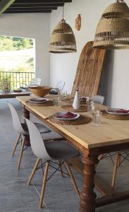 a wooden table with chairs and a wooden table with glasses at Finca Las Morenas in Yunquera