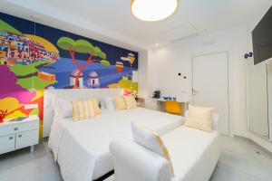 a bedroom with a white bed and a colorful wall at Amalfi Centro in Amalfi