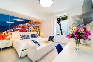um quarto com uma cama branca e um vaso de flores em Amalfi Centro em Amalfi