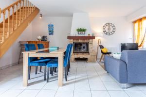 Un comedor con una mesa y sillas azules. en Holiday Normandy se ressourcer à deux pas de la Mer, en Fermanville