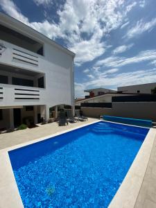 een zwembad voor een huis bij Apartments Mima in Petrcane