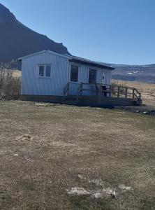 una pequeña casa blanca en un campo con un patio en Hagi 2 Road 62 nr 2, en Hagi