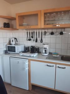 a kitchen with white cabinets and white appliances at Hagi 2 Road 62 nr 2 in Hagi