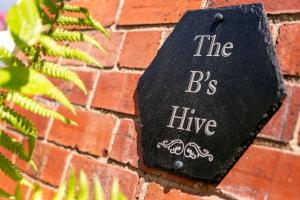 The Bs Hive, Modern, stylish, 2 bedroom house, in Harrogate centre في هاروغايت: علامة على جدار من الطوب تقول خلية bc