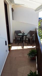 un patio con tavolo e sedie sul balcone. di Studio Callatis Central - adults only a Mangalia