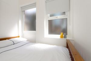 The Bs Hive, Modern, stylish, 2 bedroom house, in Harrogate centre في هاروغايت: غرفة نوم بيضاء بها سرير ونافذة