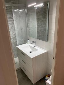 a bathroom with a white sink and a mirror at Stay U-nique Apartments Sitges Beach in Sitges