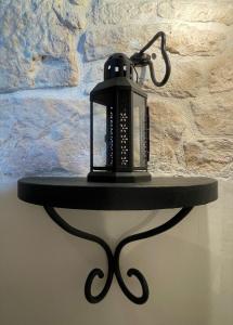a black lamp on a table in front of a wall at Masseria La Mandra in Noci