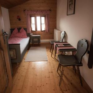 1 dormitorio con cama, escritorio y ventana en Almhaus Anita, en Rieding