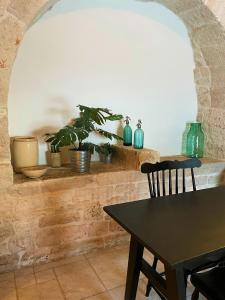 a dining room with a table and some plants at Masseria La Mandra in Noci