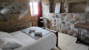 ein Schlafzimmer mit einem Bett mit Handtüchern und einem Kamin in der Unterkunft Casa Entre as Serras in Antigo de Arcos