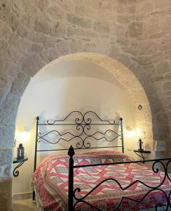 a bedroom with a bed in a stone wall at Masseria La Mandra in Noci