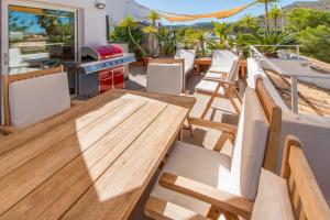 a patio with a wooden table and chairs at Beach Inn Deluxe Apartment in Alcudia