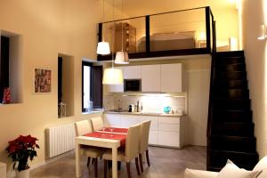 eine Küche und ein Esszimmer mit einem Tisch und einem Loft in der Unterkunft Amalfitani House in Palermo