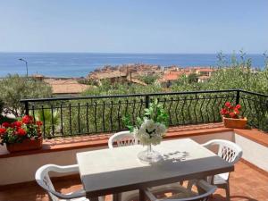 una mesa y sillas en un balcón con vistas al océano en Villa Stefania, en Marina di Camerota