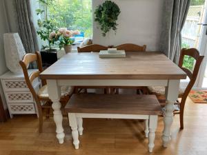 a dining room table with chairs and a wooden table and bench at Mackerel Cottage in Budleigh Salterton