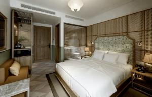 a bedroom with a large white bed and a bathroom at La Passion Hanoi Hotel & Spa in Hanoi