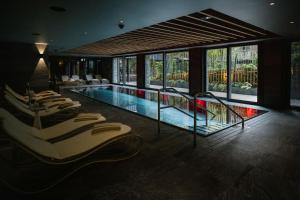 a hotel with a swimming pool with chairs and windows at Bergwelt Grindelwald - Alpine Design Resort in Grindelwald
