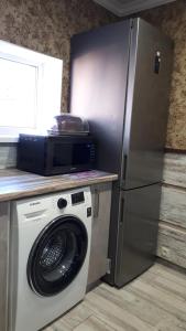 uma cozinha com uma máquina de lavar roupa e um frigorífico em Апартаменты студия, 10мин до центра, онкоцентр, томоклиника, em Kirovohrad