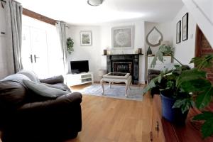 a living room with a couch and a tv at Mackerel Cottage in Budleigh Salterton